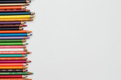 Pencils of different size and colour are lined up.