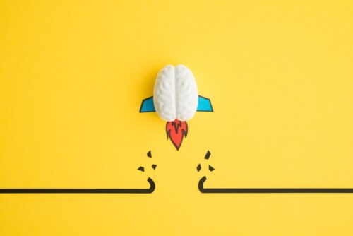 An abstract brain rocket breaks through an obstacle.