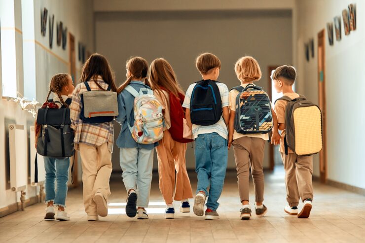 A group of children walking down a hallway.