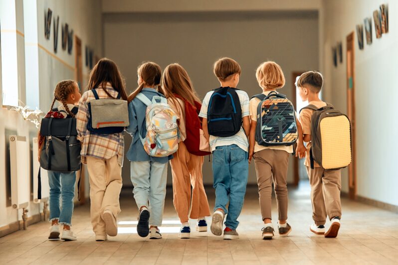 A group of children walking down a hallway.