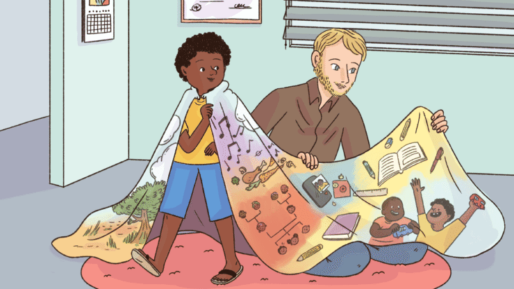 A child wears a colorful blanket of learning themes beside an adult.