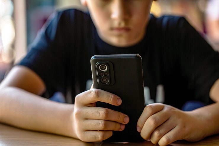 A boy looks at his phone.