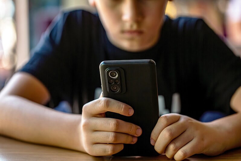 A boy looks at his phone.