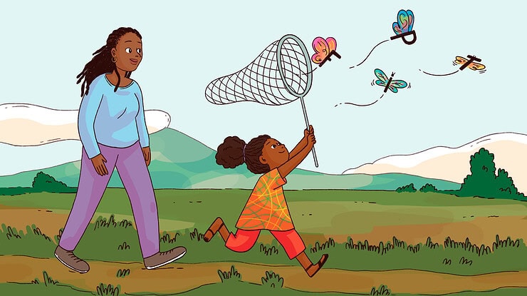 An adult watches a child catch butterflies made of letters.