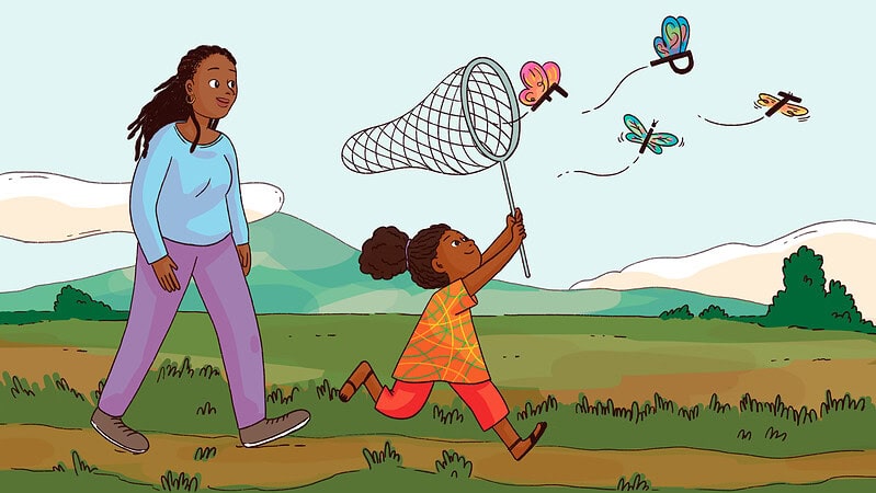 An adult watches a child catch butterflies made of letters.