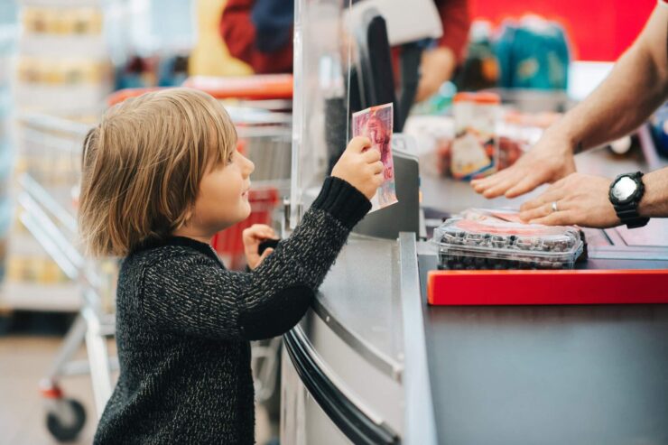 A boy is paying for groceries.