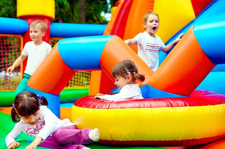 Kinder spielen auf einer Hüpfburg.