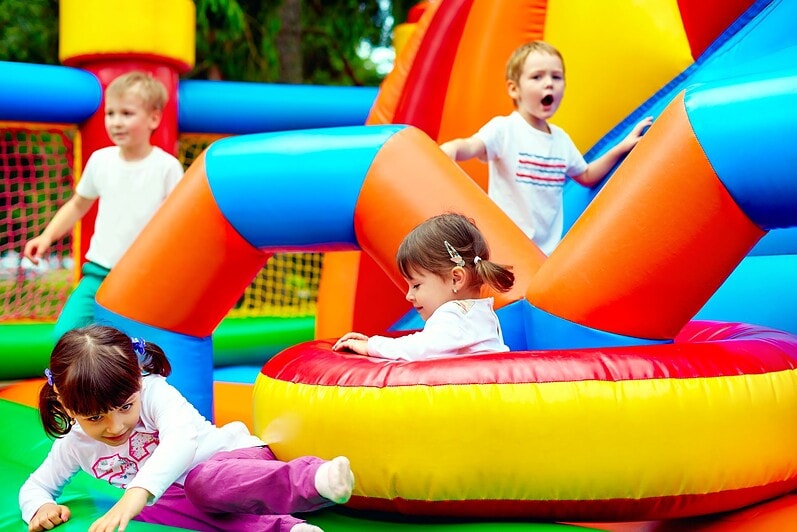 Children are playing on a bouncy castle.