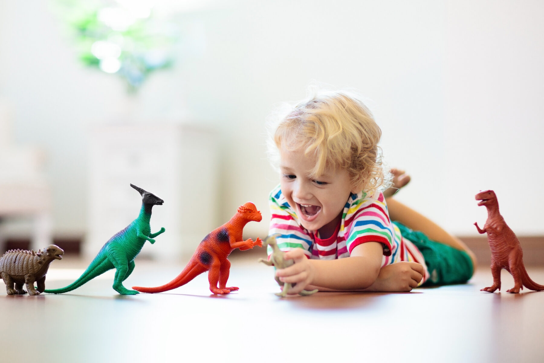 A child is playing with toy dinosaurs.