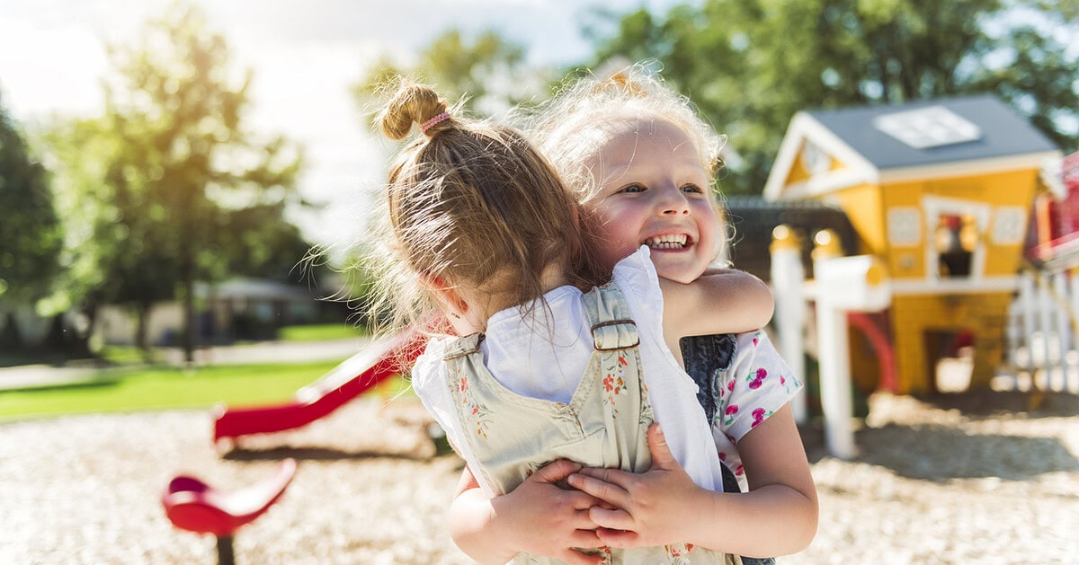 Two children hugging while playing outdoors