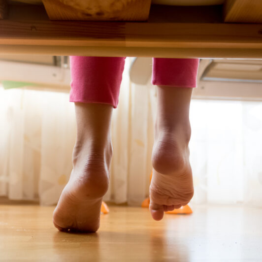 A teenager is getting out of bed.