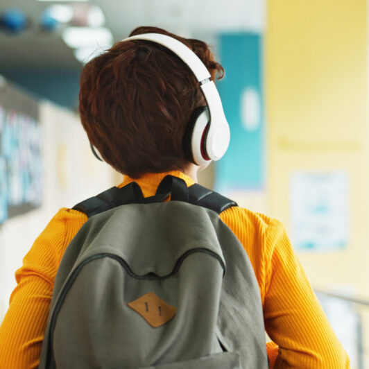 A child is walking in school wearing headphones.