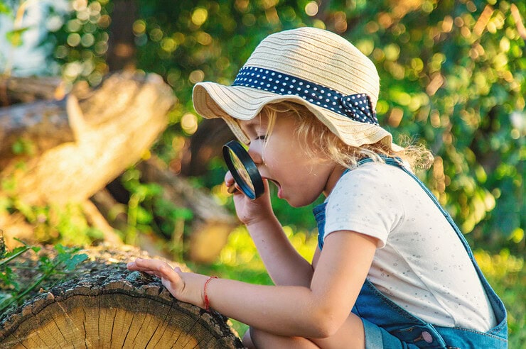 A child looks through a magnifying glass.