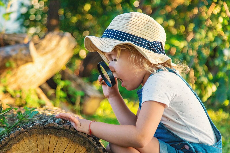 A child looks through a magnifying glass.