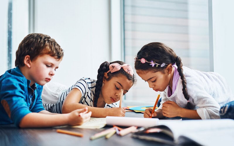 Children complete schoolwork together.
