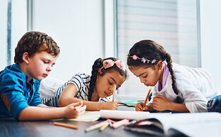 Children completing schoolwork together.