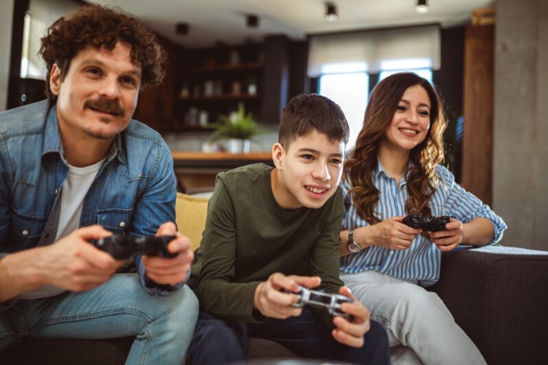 A family play a video game together.