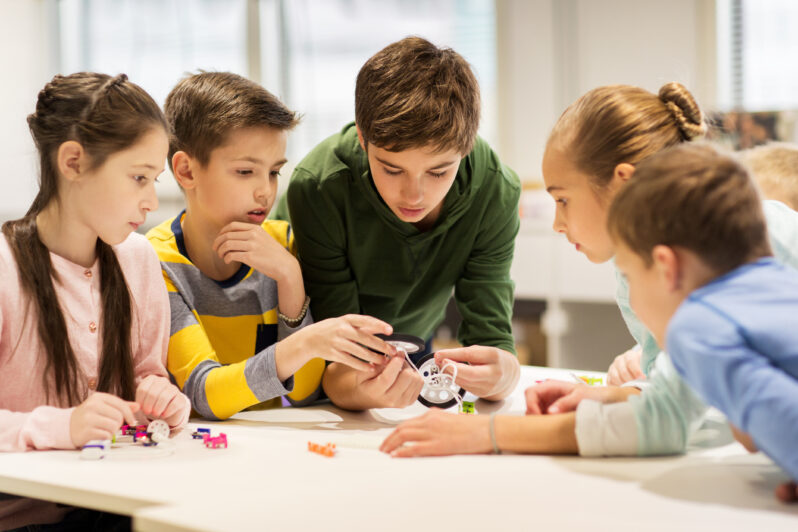 A group of children problem solve together.