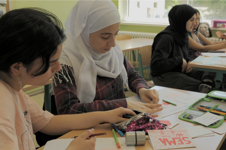 Diverse students are doing an activity in a classroom.