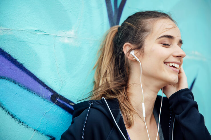A teenager listens to music on headphones.