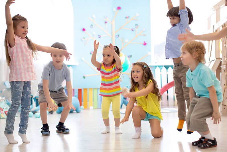 A group of children dance.
