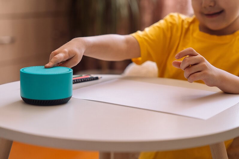 A child presses on a smart speaker.