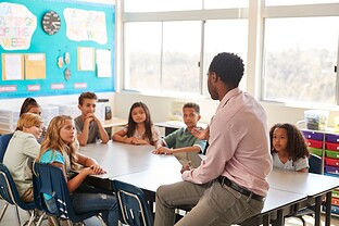 A teacher is leading a discussion with students in the classroom.