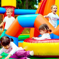 Children are playing on a bouncy castle.