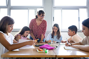 Students learn with their teacher in school.