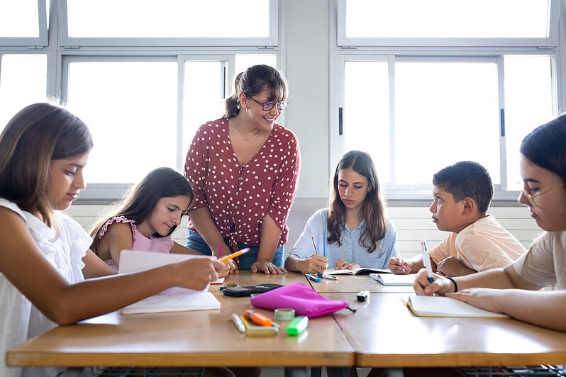 Students learn with their teacher in school.